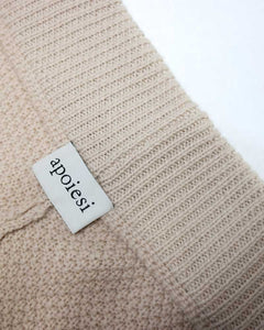 Close up of the inside waistband and brand label of apoiesi Aud knitted trouser